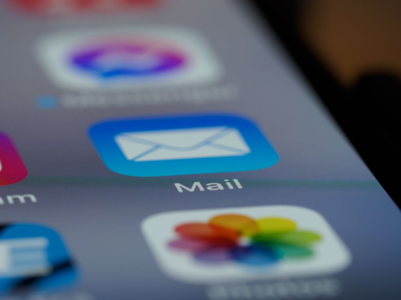 Gros plan détaillé sur l’icône d’une application email à l’écran d’un smartphone, mettant en avant une technologie moderne.